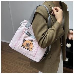 Detailed view of pink canvas tote bag featuring a cute cartoon capybara embroidery patch