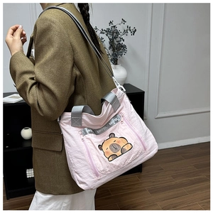 Detail of pink nylon tote bag with cute capybara print and grey logo-printed straps
