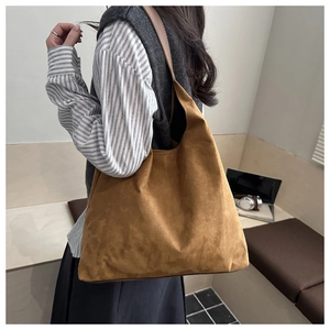 Dettaglio della borsa tote in pelle scamosciata marrone con manici in cuoio