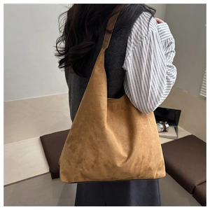 Dettaglio della borsa tote in pelle scamosciata color caramello con texture opaca e tracolla