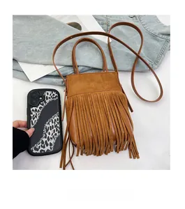 Dettaglio mini borsa in camoscio marrone con lunghe nappe che mostrano trama e dimensioni