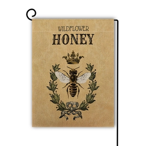 Detail of wildflower honey garden flag with vintage bee design and burlap texture
