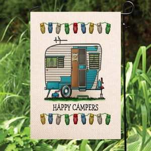 Linen garden flag with Happy Campers RV design hanging on a black stand in a green garden