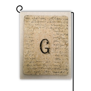 Dettaglio della bandiera da giardino vintage in lino con lettera G e scritte corsive