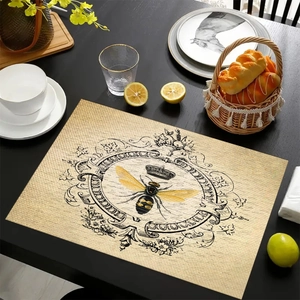 Macro detail of rectangle linen placemat featuring a vintage bee crown and floral pattern