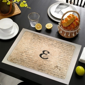 Dettaglio della tovaglietta in lino con lettera E vintage e calligrafia nera elegante