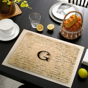 Tovaglietta in lino con lettera G su tavolo in legno per decorazione di cucina