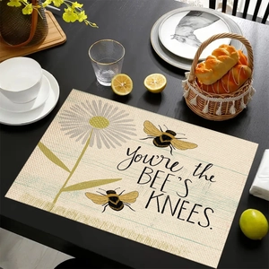 Linen placemat with bee and daisy design and You're the BEE'S KNEES text on black table