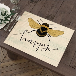 Linen placemat with bee print and happy text on dark wood table for kitchen decor