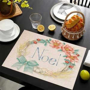 Detail view of linen Christmas placemat with Noel text and festive floral wreath decor