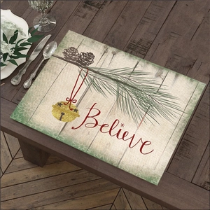 Christmas linen placemat featuring Believe lettering and festive pine needle design