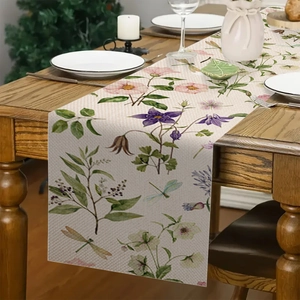 Dettaglio del runner da tavola in lino con fiori e libellule su un tavolo di legno