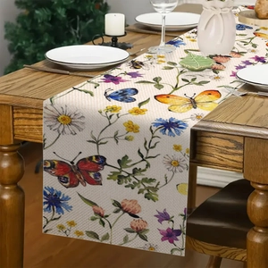 Dettaglio del runner da tavolo in lino con motivi a fiori colorati e farfalle