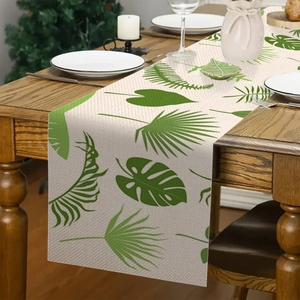 Tropische groene bladeren op linnen tafelloper voor decoratie in de eetkamer