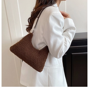 Brown fuzzy faux shearling tote bag for women worn by a model in a white blazer