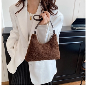 Detail of dark brown plush shoulder bag showing faux shearling texture and leather strap