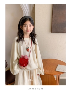 Kids red patent crossbody bag with plaid bow detail paired with strawberry necklace