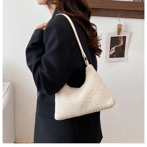 Detail of white plush sherpa hobo bag showing fluffy texture and leather strap on model
