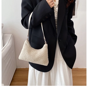 Faux shearling crescent bag in off-white shown on model in minimalist interior setting