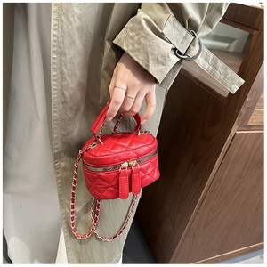 Detail of red quilted leather box bag with gold chain strap and dual zipper closure