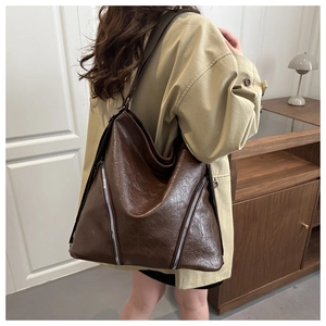 Dettaglio di una borsa tote vintage marrone scuro con cerniere argentate simmetriche