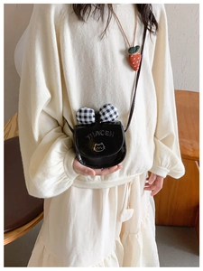 Detail of kids black patent crossbody bag with plaid bow and cat embroidery