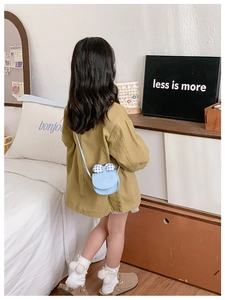 Detail of light blue kids crossbody bag featuring plaid bows on a little girl
