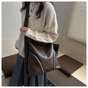 Dettaglio borsa tote vintage marrone con texture cerata e cerniere argentate decorative