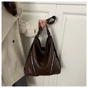 Dettaglio della borsa tote in pelle marrone scuro con eleganti cerniere argentate