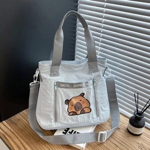 Cute light blue nylon capybara tote bag with adjustable straps and multi-pocket design