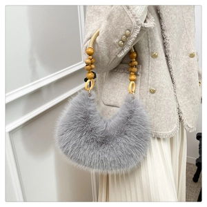 Détail du sac lune en fausse fourrure grise avec poignée en perles de bois et texture douce