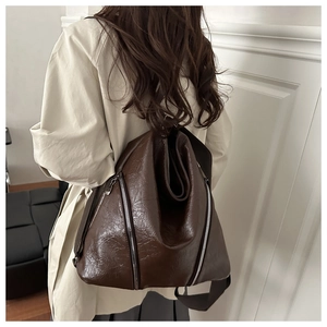 Dettaglio della texture in finta pelle marrone vintage e cerniera argento sulla borsa