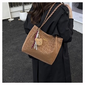Dettaglio borsa shopper leopardata con tracolla intrecciata e ciondolo a forma di orso