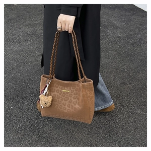 Dettaglio della borsa tote leopardata con logo Creative Cat e ciondolo orsetto