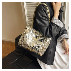 Dettaglio ravvicinato di paillettes metalliche e tracolla a catena intrecciata della borsa