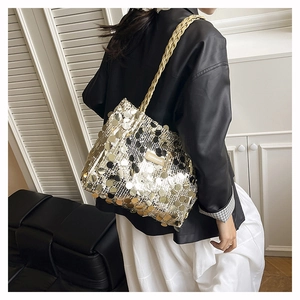 Dettaglio delle paillettes metalliche dorate e della tracolla intrecciata della borsa