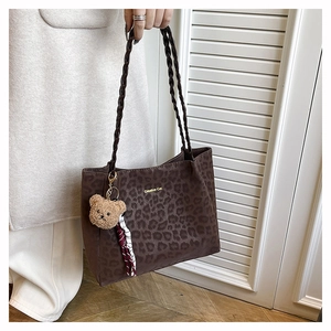 Dettaglio borsa shopper leopardata con manici intrecciati e ciondolo orsetto