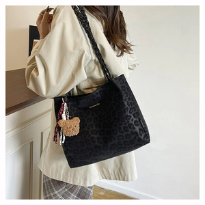 Dettaglio della borsa tote leopardata nera con logo Creative Cat e ciondolo orsetto