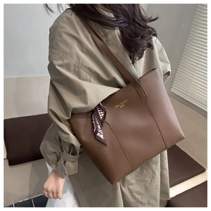 Dettaglio borsa tote in pelle marrone scuro con foulard di seta e cuciture verticali