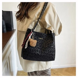 Dettaglio della borsa tote leopardata grigia con tracolla intrecciata e ciondolo orsetto