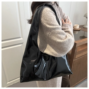 Dettaglio borsa hobo nera lucida con finitura a specchio e design capiente moderno