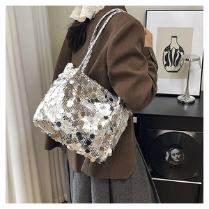 Dettaglio della borsa a spalla con paillettes argento, spalline intrecciate e riflessi