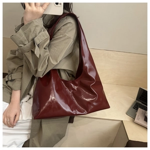 Dettaglio di una borsa tote bordeaux lucida realizzata in ecopelle di alta qualità