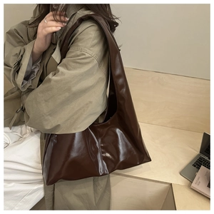 Dettaglio di una grande borsa tote marrone cioccolato con texture in pelle lucida