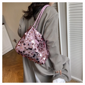 Dettaglio borsa a spalla con paillettes rosa, manici intrecciati e logo in pelle