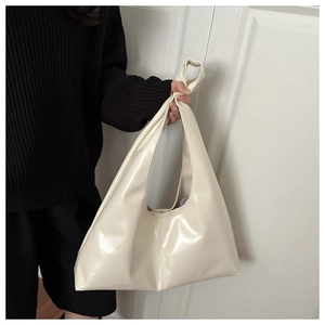Dettaglio di una borsa hobo crema di grandi dimensioni con finitura lucida e trama morbida