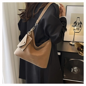 Detail of vintage camel leather bucket bag with a small matching pouch and fashion logo
