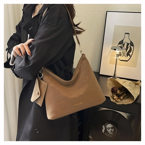Brown suede tote bag with small card pouch shown in a stylish interior setting