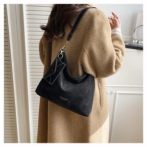 Detail of black tote bag with white contrast stitching and a small triangle pouch accessory