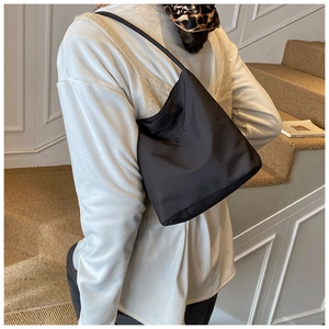 Vue détaillée d'un sac cabas noir avec lettrage 'Hope', porté par un mannequin à l'épaule